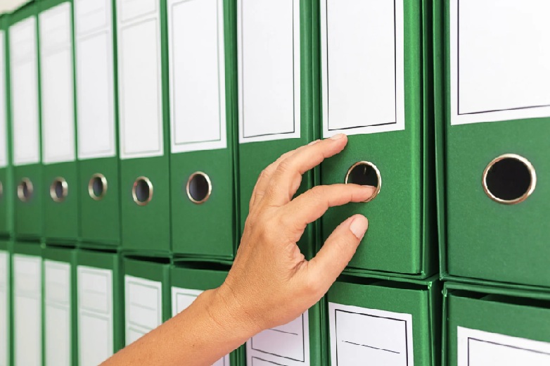 Compliance officer reaching for case files and AML documents